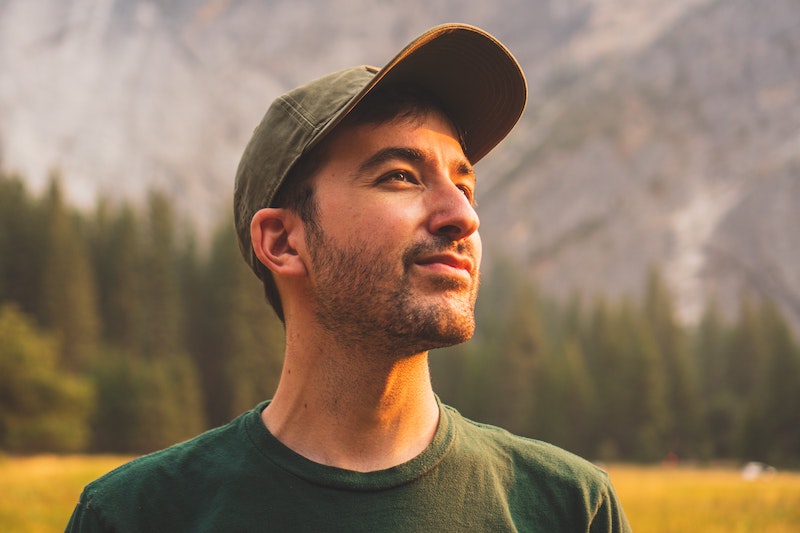 henry in nature looking away at the distance with clothing on looking happy